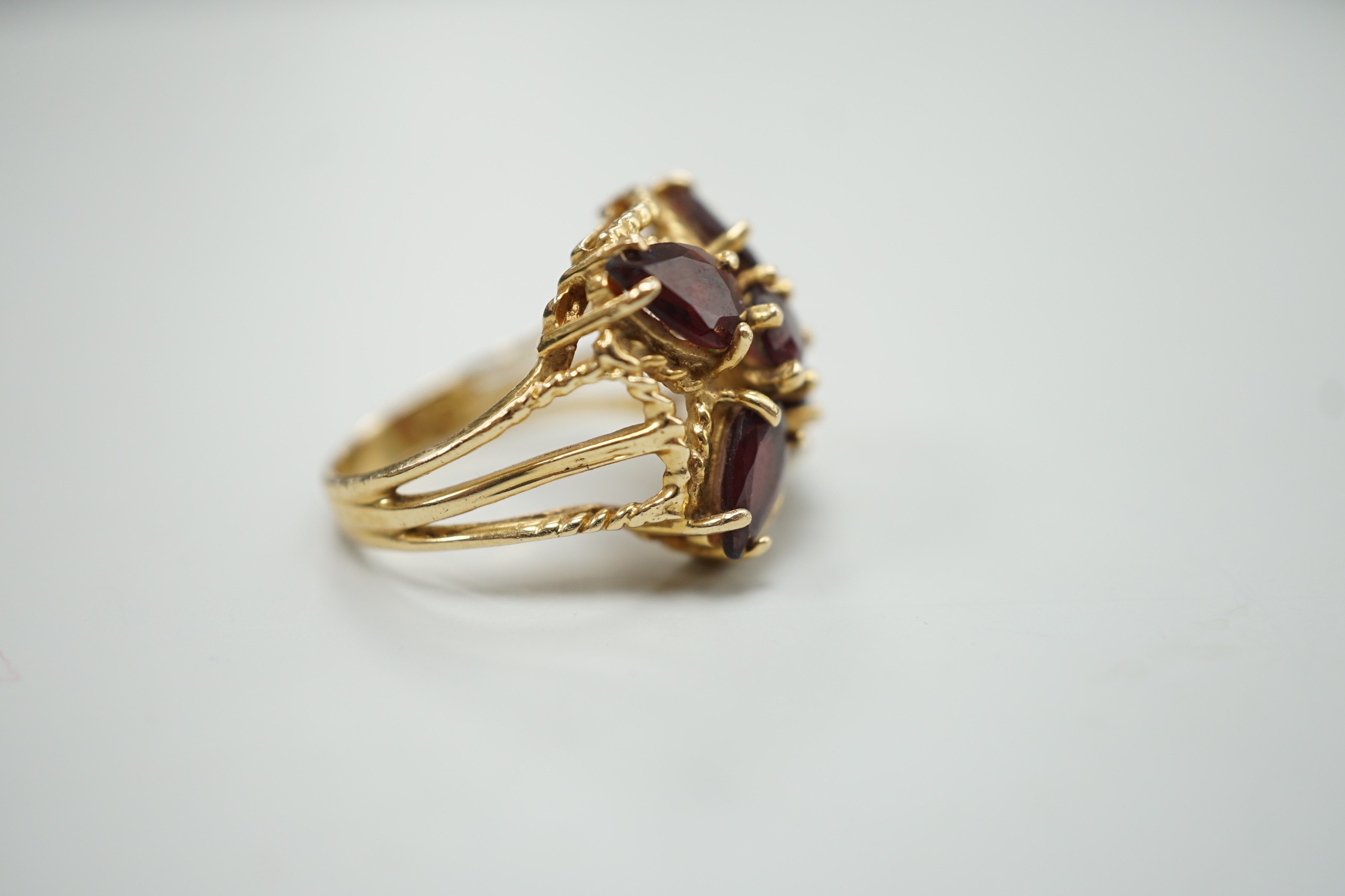 A modern 585 yellow metal and five stone garnet cluster set dress ring, size K/L
